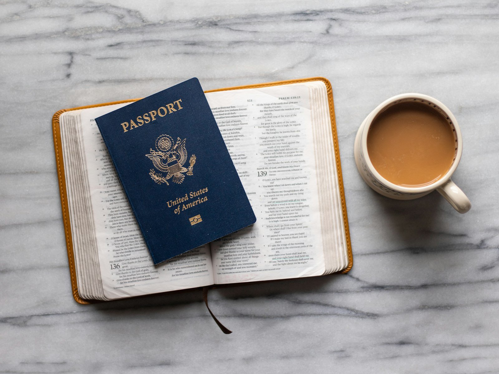 Passport on an open notebook next to a cup of tea